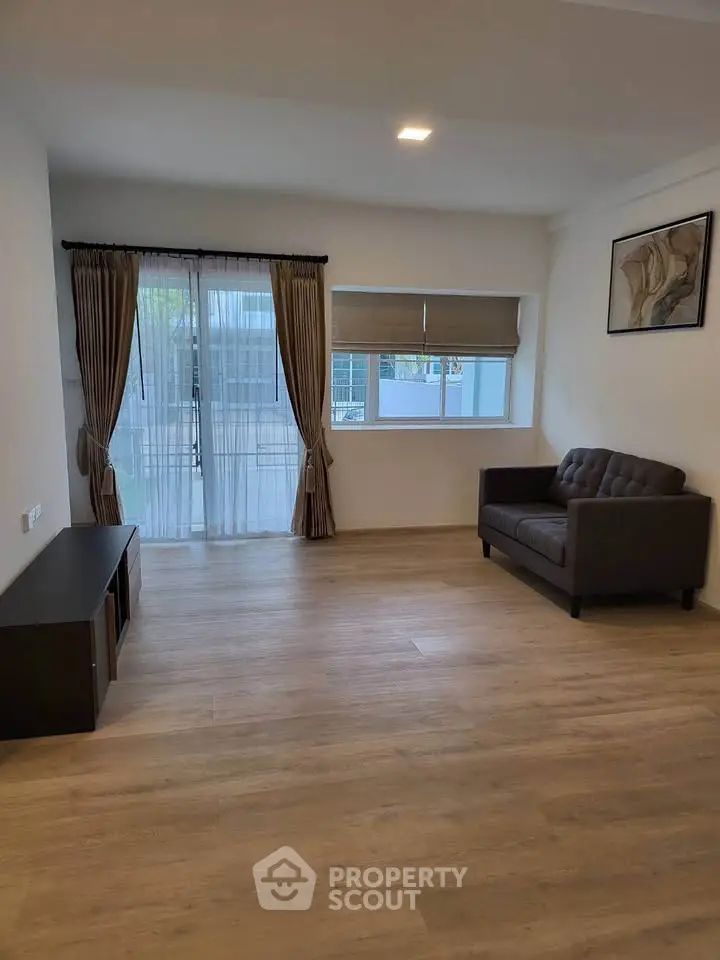 Spacious living room with modern decor and large windows for natural light.