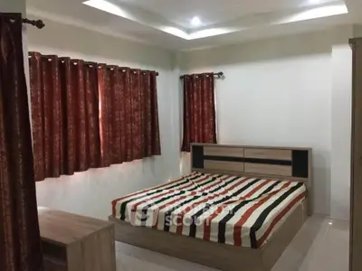 Spacious bedroom with modern wooden furniture and stylish curtains, perfect for a cozy retreat.