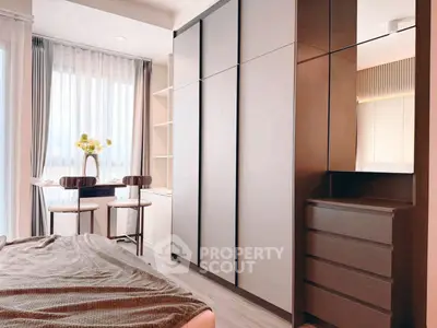 Modern bedroom with sleek wardrobe and cozy seating area, perfect for urban living.