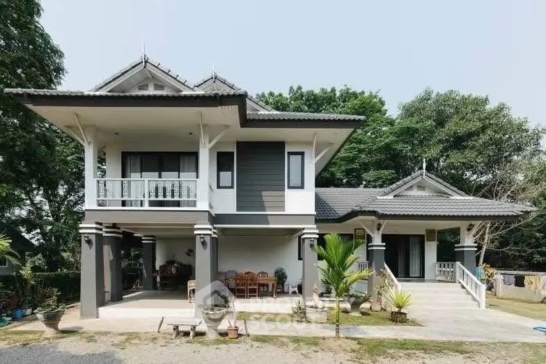 Charming two-story house with spacious balcony and lush greenery, perfect for serene living.