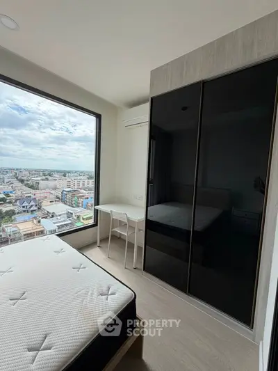 Modern bedroom with large window offering stunning city view, featuring sleek wardrobe and minimalist decor.