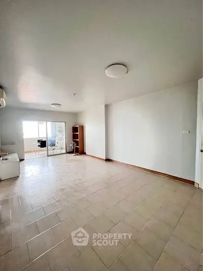 Spacious unfurnished living room with tiled flooring and natural light