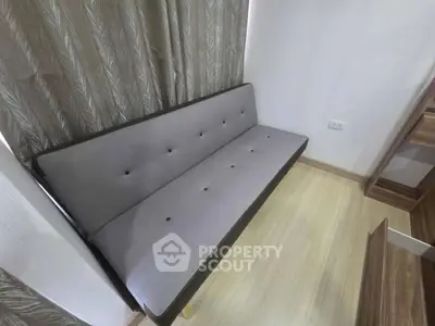 Modern minimalist sofa in cozy living room with wooden flooring and elegant curtains.