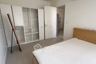 Spacious bedroom with modern wardrobe and cozy bed in a minimalist design.