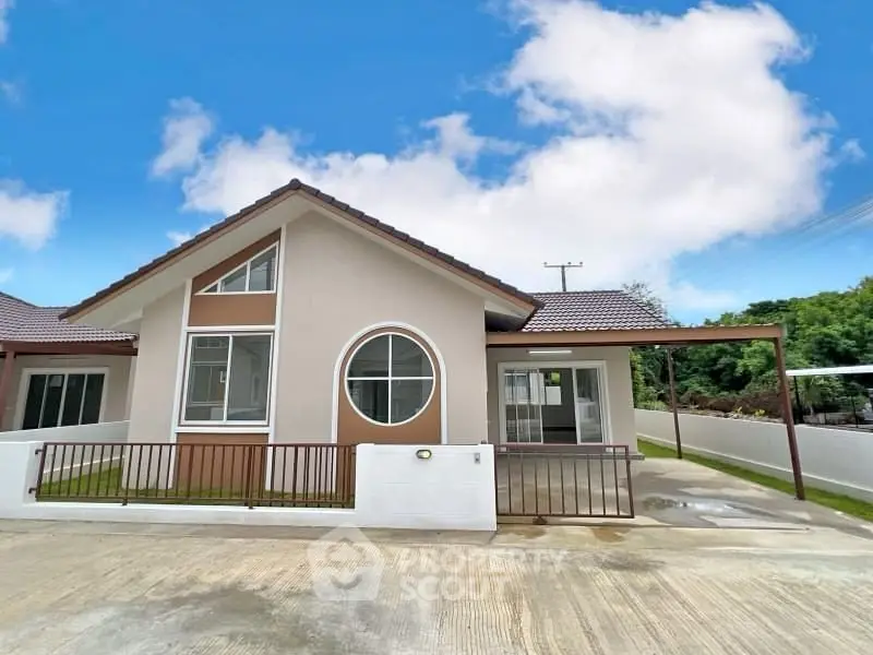 Charming single-story house with unique circular window and spacious driveway in a serene neighborhood.