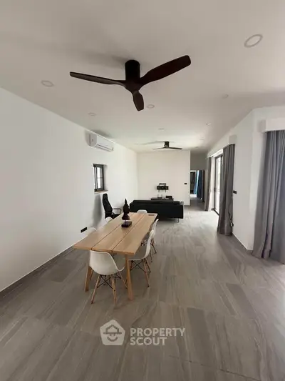 Spacious modern living room with sleek dining area and stylish ceiling fan