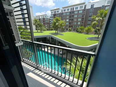 Modern apartment balcony with pool and garden view in urban setting