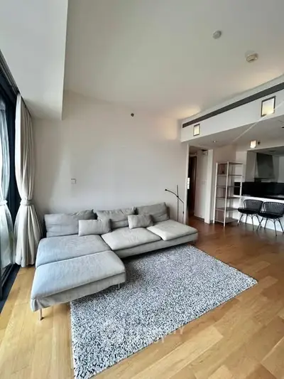 Modern living room with sleek gray sofa and open kitchen layout