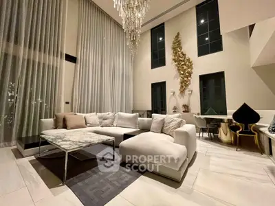 Luxurious high-ceiling living room with elegant chandelier and modern decor