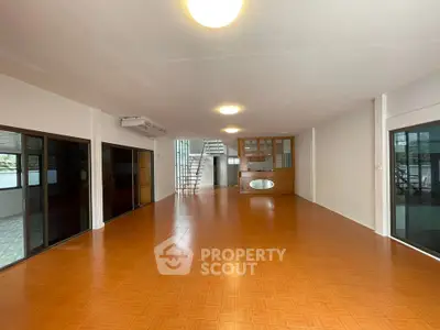Spacious open-plan living area with modern lighting and large windows.