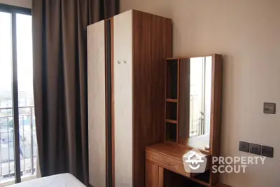 Modern bedroom with wooden wardrobe and dressing table near large window.