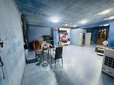 Spacious blue-themed living room with modern furniture and entertainment setup.