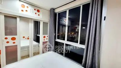 Modern bedroom with city view and stylish wardrobe in high-rise apartment.