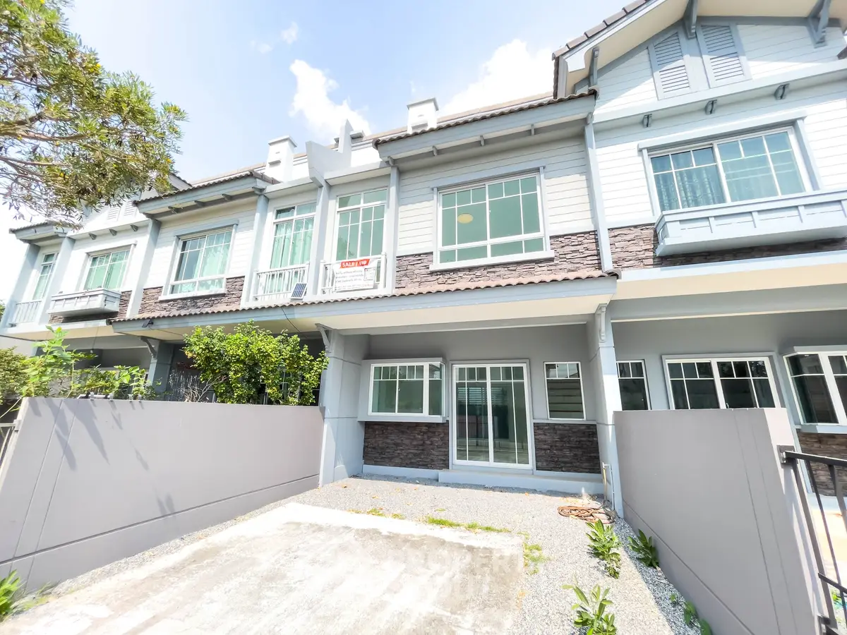 Charming townhouse exterior with modern design and spacious driveway in a serene neighborhood.