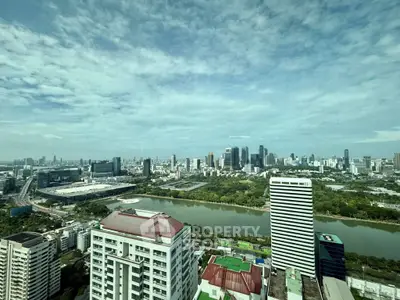 Stunning cityscape view from high-rise apartment overlooking river and skyline.