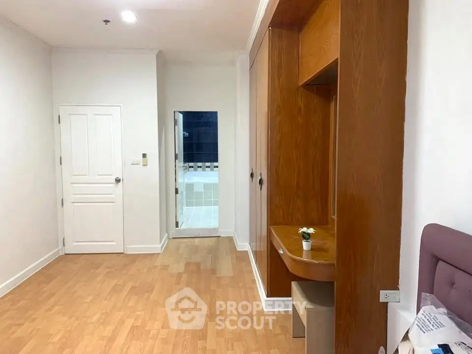 Spacious bedroom with wooden flooring and built-in wardrobe