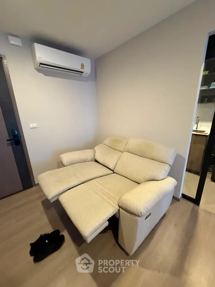 Cozy living room with reclining sofa and modern air conditioning unit