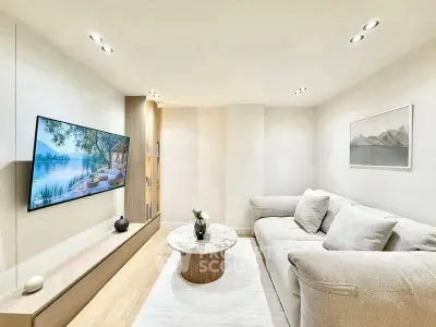 Modern living room with cozy sofa and wall-mounted TV, perfect for relaxation.