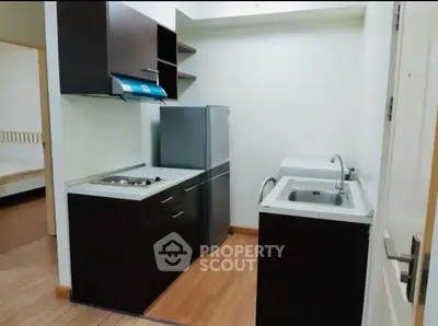 Compact kitchen with modern appliances and sleek cabinetry in cozy apartment.