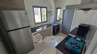 Modern kitchen with sleek appliances and gas stove in a stylish home.
