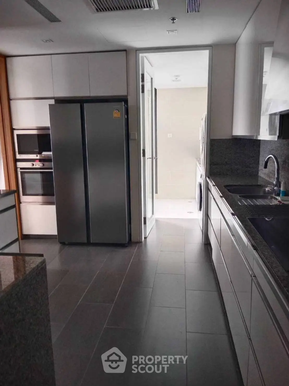 Modern kitchen with sleek appliances and granite countertops in a contemporary home.