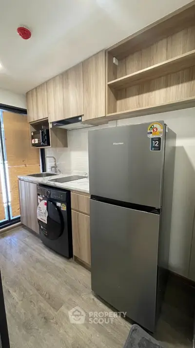 Modern kitchen with sleek appliances and wooden cabinetry in a stylish apartment