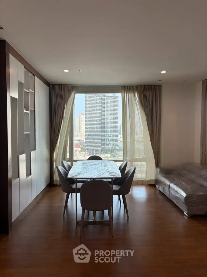 Spacious living room with city view, elegant dining area, and modern furnishings.