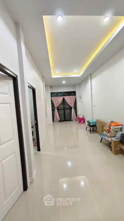 Spacious modern living room with glossy tile flooring and recessed lighting, featuring a large window with pink curtains.