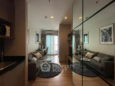 Modern living room with stylish decor and mirrored wall in a cozy apartment.