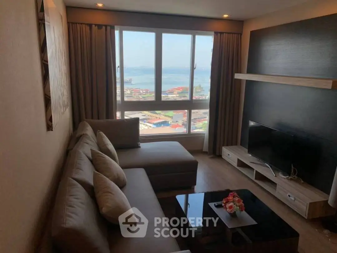 Chic living room with stunning sea view, modern sofa, and sleek TV setup.