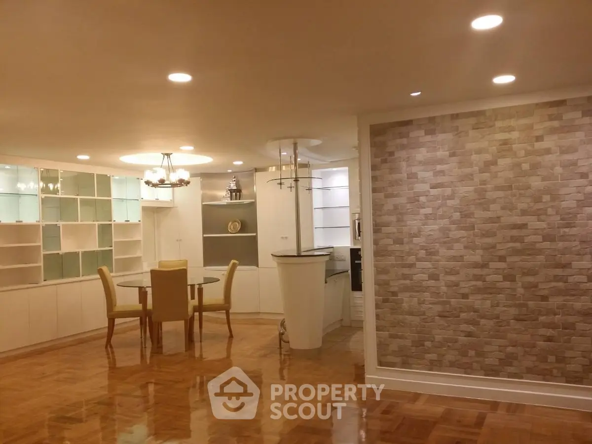 Spacious open-plan living and dining area with elegant lighting and parquet flooring.