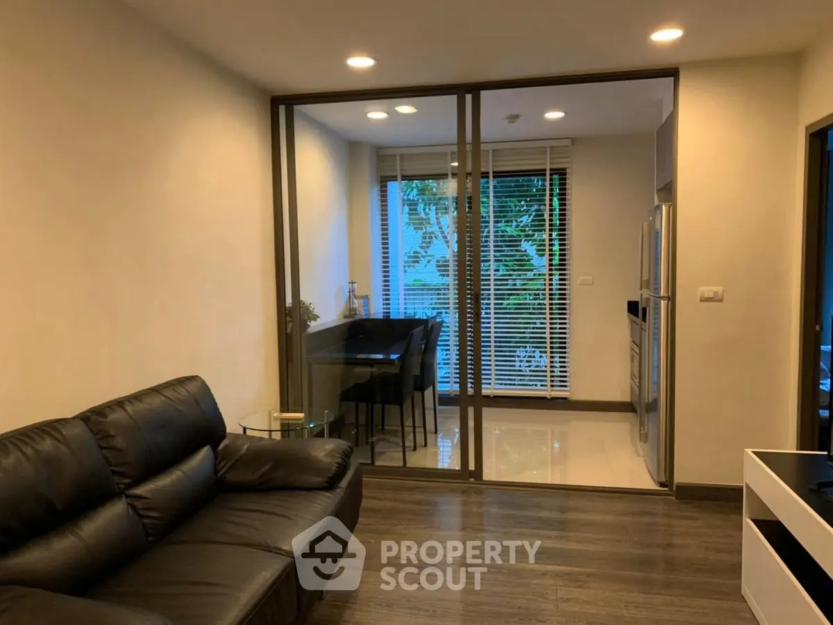 Modern living room with glass partition and cozy seating area, perfect for urban living.