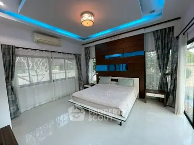Luxurious bedroom with modern lighting and large windows offering serene views.