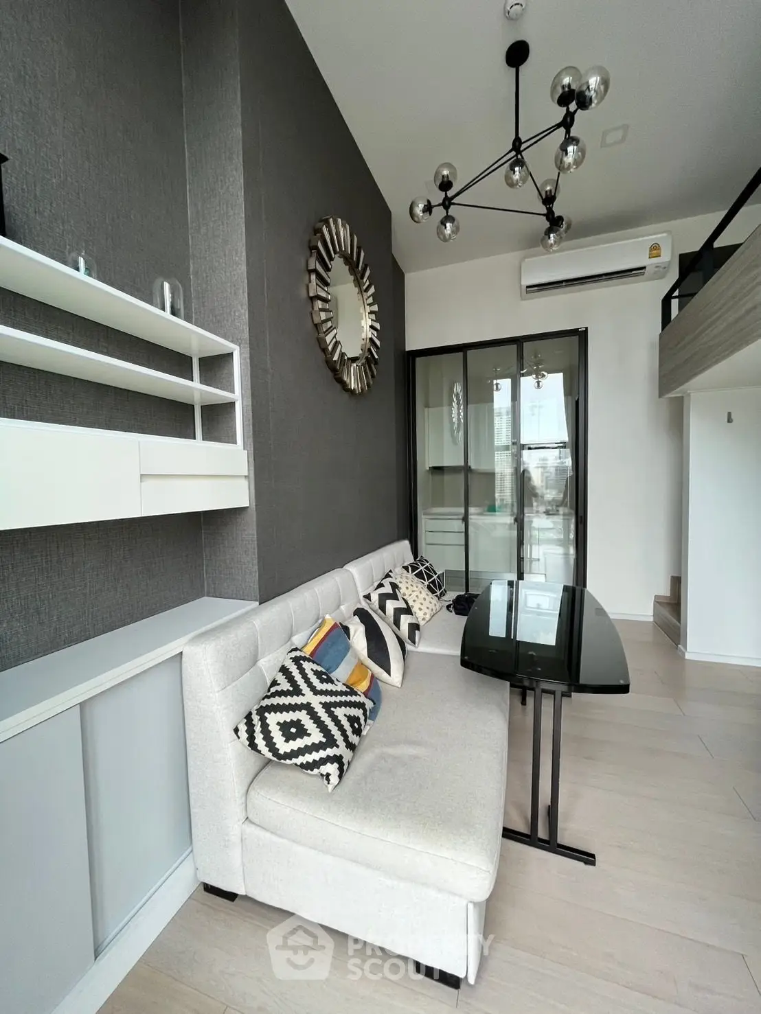 Modern living room with stylish decor and high ceiling, featuring a chic chandelier and cozy sofa.