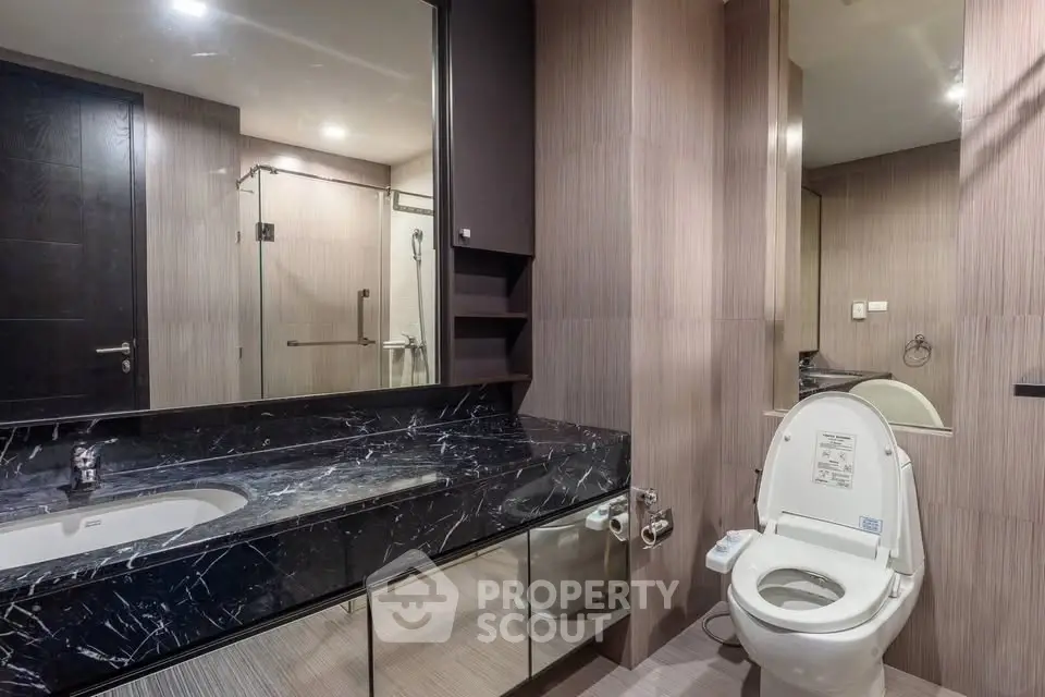 Luxurious modern bathroom with sleek marble countertop and elegant fixtures.
