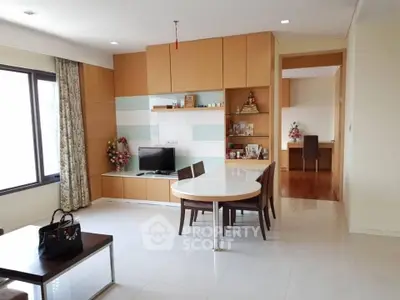 Modern living room with dining area and built-in storage, featuring elegant decor and natural light.