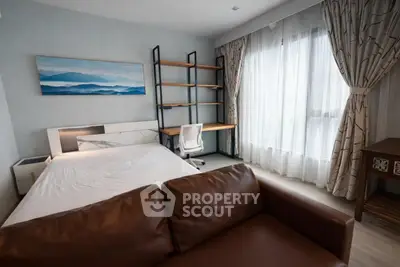Modern bedroom with study area and large window, featuring elegant decor and natural light.