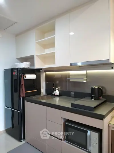 Modern kitchen with sleek appliances and open shelving in a compact layout.