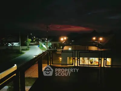 Stunning night view from a modern balcony overlooking a quiet residential street.