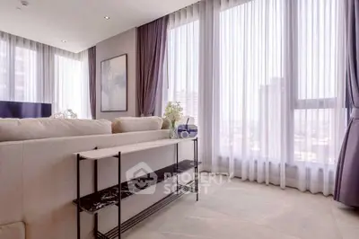 Spacious and bright living room with large windows and elegant decor