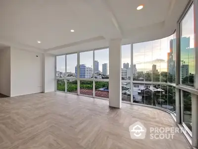 Spacious and bright corner unit with floor-to-ceiling windows offering panoramic city views, perfect for a luxurious living room setup.