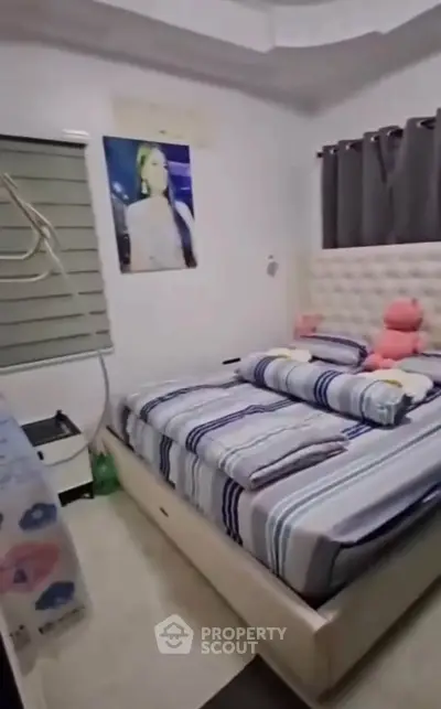 Cozy bedroom with plush bed and modern decor, perfect for relaxation.