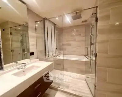 Luxurious modern bathroom with glass shower and elegant fixtures.