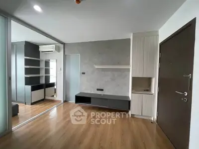 Modern living room with sleek wooden flooring and built-in storage solutions.