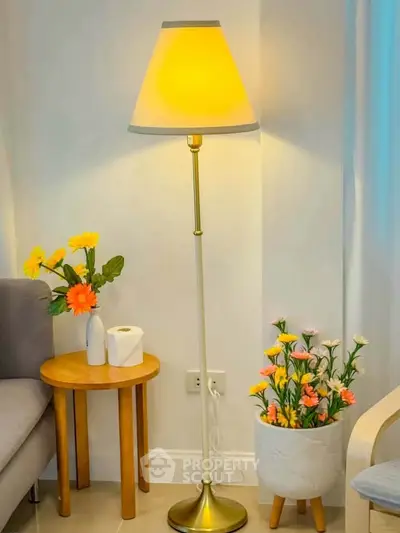 Cozy living room corner with elegant floor lamp and vibrant floral decor.