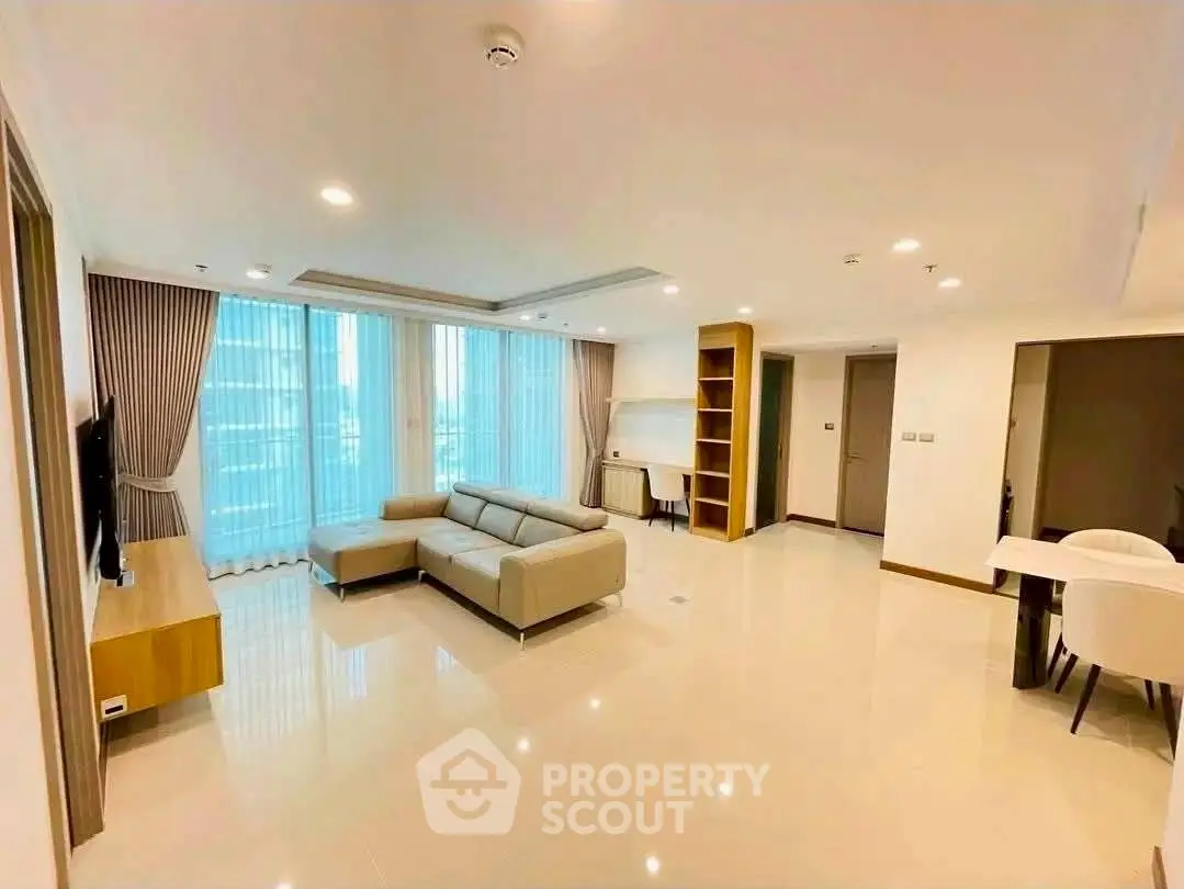 Spacious modern living room with elegant furniture and large windows in a luxury apartment.