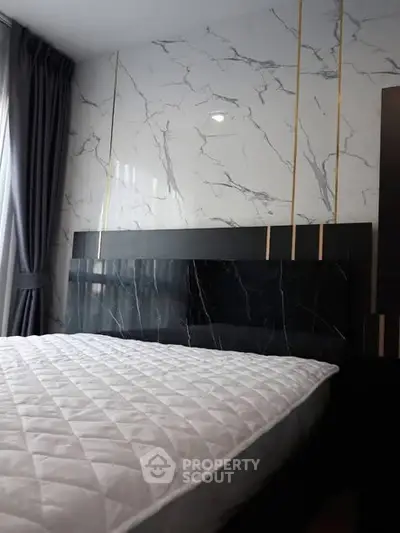 Luxurious bedroom with elegant marble accent wall and plush bedding