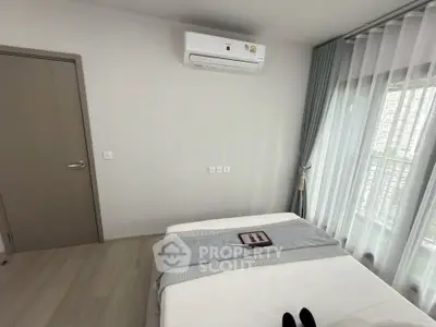 Modern bedroom with air conditioning and large window for natural light