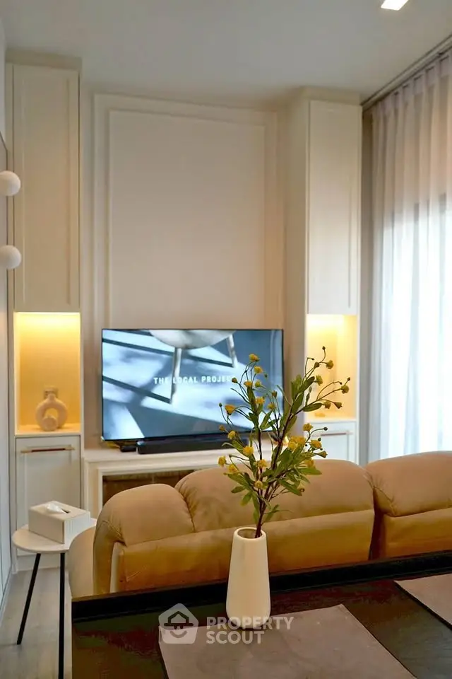 Modern living room with stylish decor and large TV, perfect for relaxation and entertainment.