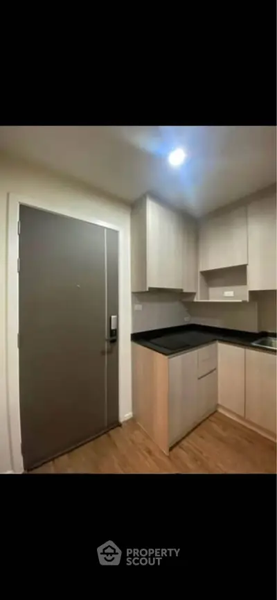 Modern kitchen with sleek cabinetry and wood flooring in a contemporary apartment.